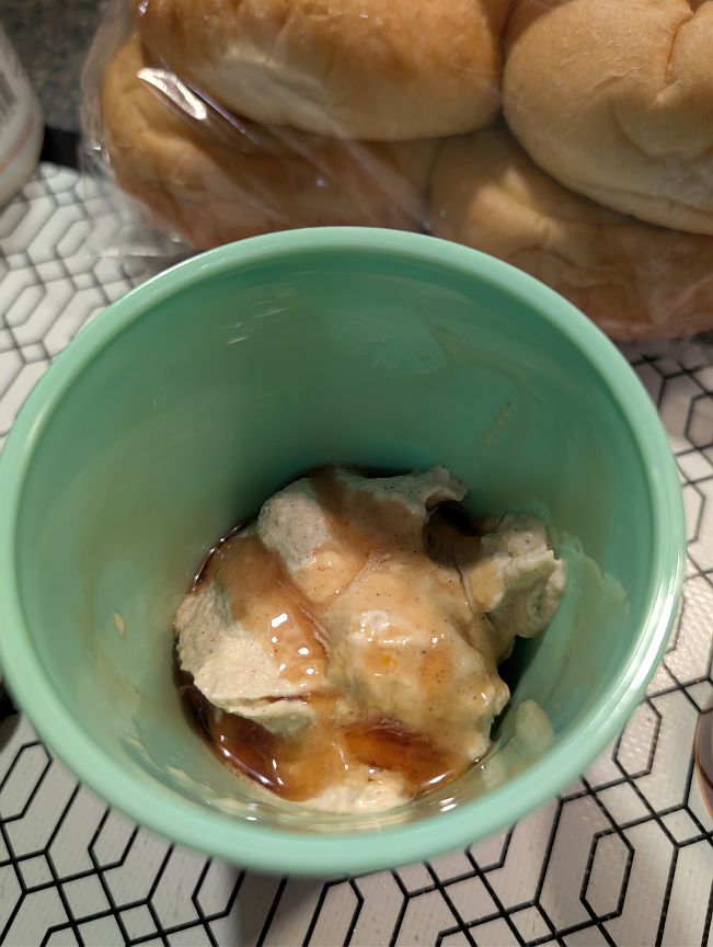 Frozen pumpkin gelato topped with maple syrup in a green cup