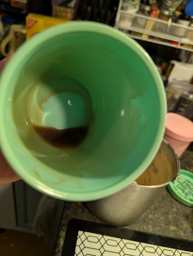 Green serving cup coated inside with maple syrup