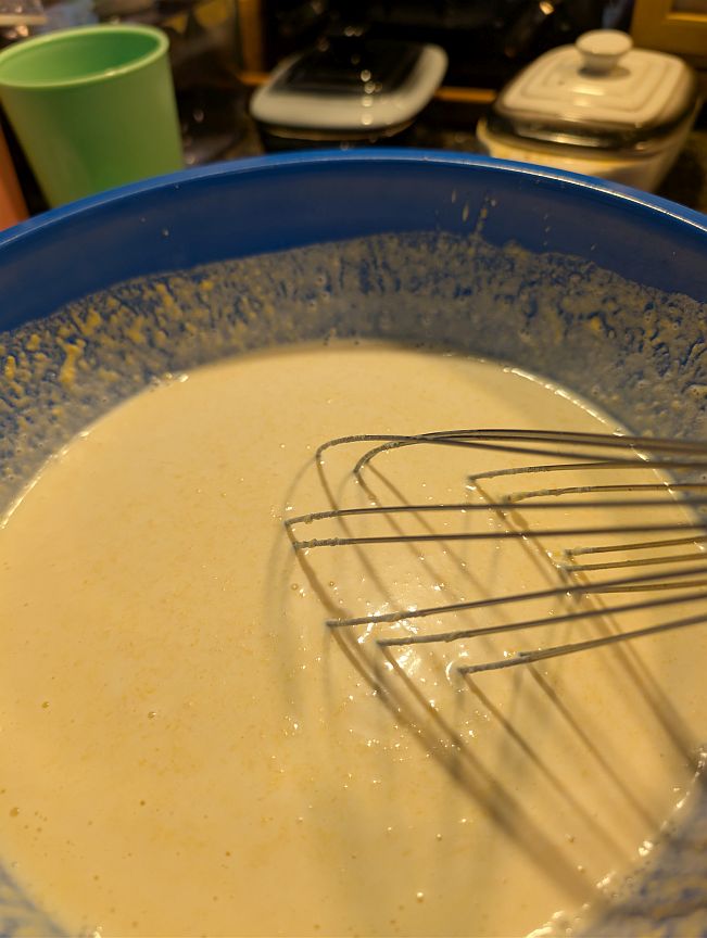 Pumpkin gelato base being whisked in a blue bowl